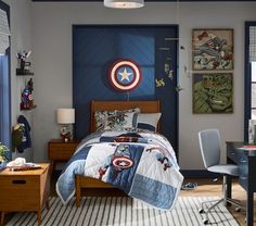 a bedroom decorated in blue and grey with captain america bedding