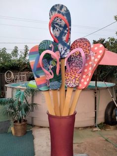 a vase filled with flip flops and umbrellas sitting on top of a table