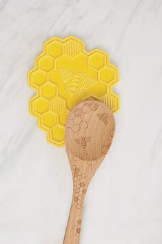 a wooden spoon sitting on top of a table next to a honeycomb shaped cookie