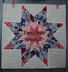 a red, white and blue star quilt hanging on a wall