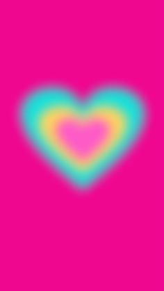 a heart shaped object on a pink background with blue, yellow and green colors in the center