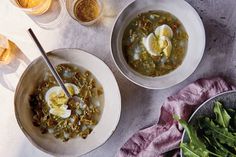 two bowls of soup with eggs and greens