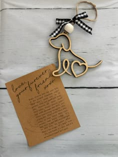 a wooden dog ornament with a note attached to it on a white table