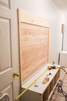 a room with some tools on the floor next to a wooden paneled headboard