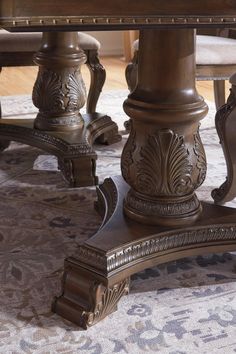 a dining room table and chairs with an ornate pattern on the carpeted flooring