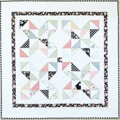 a white quilt with black and pink designs on it