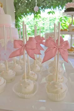 some cupcakes with pink bows are on a table