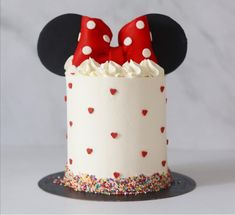 a mickey mouse cake with red and white polka dot bows on it's head