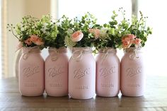 four pink mason jars with flowers in them