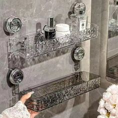 a person is touching the glass shelves in a bathroom