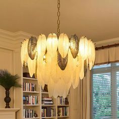 a chandelier hanging from the ceiling in a living room with bookshelves