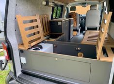 the interior of a van with wooden furniture in it