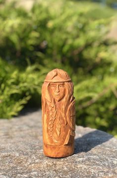 a small wooden object sitting on top of a rock