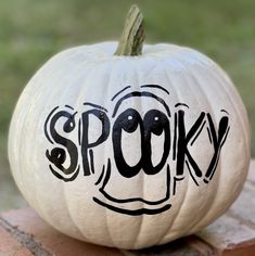 a white pumpkin with the word spooky painted on it