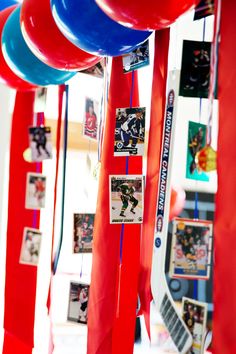 red, white and blue streamers hanging from the ceiling with pictures on them in front of a window