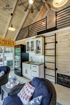 a living room filled with furniture next to a kitchen