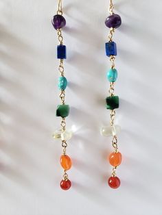 "Vibrant gemstones wired wrapped in your choice of 14k goldfilled or sterling silver wire. Gems are rich in color and coordinate with the seven energetic Chakra colors. From top to bottom, it includes amethyst, lapis, apatite, (turquoise for gold version),  jade, citrine, carnelian and red agate. Earrings hang 4\" in length.  It's said that wearing or holding certain stones helps keep us more in balanced with our emotions and attract good energy. Each stone coraltes with a part of the body from 14k Gold-filled Yellow Gold Earrings With Natural Stones, Bohemian Yellow Gold Wire-wrapped Earrings, Bohemian Yellow Gold Wire Wrapped Earrings, Handmade 14k Gold Filled Dangle Linear Earrings, Yellow Gold Wire Wrapped Jewelry For Healing, Bohemian 14k Gold Filled Wire Wrapped Jewelry, Spiritual 14k Gold Filled Dangle Jewelry, 14k Gold Wire Wrapped Dangle Earrings, Gold Plated Wire Wrapped Dangle Earrings