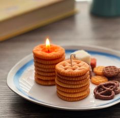 a plate topped with cookies and crackers next to a lit candle