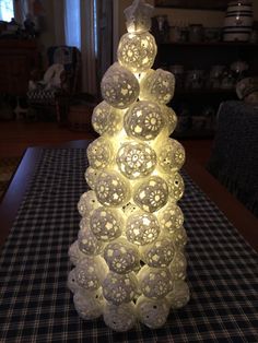 a lit up christmas tree sitting on top of a table