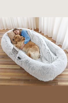 a woman laying on top of a dog bed