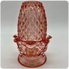 a pink glass vase sitting on top of a table