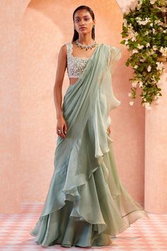 📌Hey! Please message us if you have any questions. We'll definitely assist you. A sea green net handwork blouse paired with an organza draped ruffle saree sounds like a stunning and stylish Indian ethnic outfit. Here's a breakdown of the components: Blouse: The blouse is made of sea green net fabric, which is a lightweight and sheer material. It may have handwork, which can include various types of embellishments like embroidery, sequins, beads, or zari work. This handwork adds a touch of elega Ruffle Saree Designs, Bestie Poses, Mehandi Outfits, Optical Illusion Dress, Handwork Blouse, Ridhi Mehra, Draped Saree, Ruffle Saree, Drape Saree