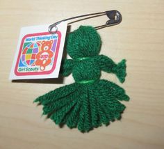 a green stuffed animal with a tag hanging from it's side on a wooden surface