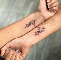 two people holding hands with tattoos on their arms and one has a dog in a bow