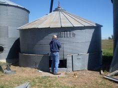 a man standing in front of two silos