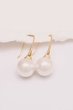 Sleek and chic, these minimal pearl earrings are trendy, yet timeless. Perfect for brides or everyday wear. Dimensions: Hangs 1.5", Pearl is 14mm Materials: Simulated Pearl, Copper, 18k Gold Plating Ships in a branded jewelry pouch and box, perfect for gift giving! Pearl Drop Earrings, Pearl Drop, Jewelry Pouch, Gift Giving, Gold Plating, Everyday Wear, 18k Gold, Pearl Earrings, Gold Plate