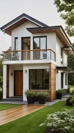 a white house with wood trim and balconies on the roof, grass in front