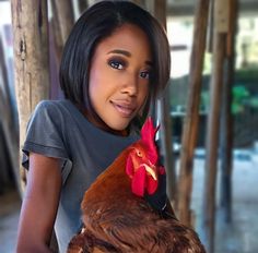 a woman holding a rooster in her hands