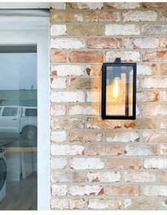 a light that is on the side of a brick wall next to a white truck