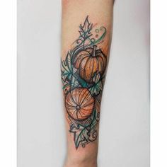 a woman's leg with tattoos on it and an orange pumpkin in the center