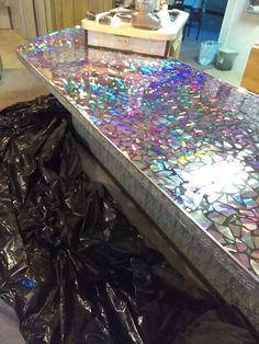 the counter is covered in plastic and has many different colored glass shards all over it