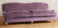 a purple couch sitting on top of a hard wood floor