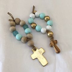 a rosary with a gold cross on it and two other beads attached to it, sitting on a white sheet