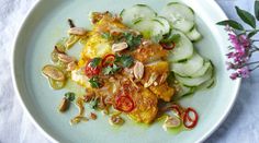 a white plate topped with cucumbers and other food