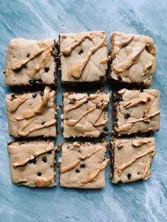 chocolate chip cookie bars with peanut butter frosting on a blue tablecloth, ready to be eaten