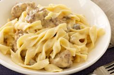 a white bowl filled with pasta and meatballs