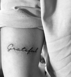 a woman's thigh with the word grateful written on it, in cursive font