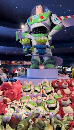 the toy story book character is surrounded by stuffed animals and other toys in an indoor mall