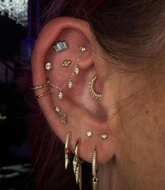 a close up of a person's ear with different types of piercings on it