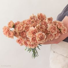 a person holding a bouquet of flowers in their hand with the other arm behind them