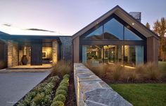 a modern house with large windows and stone walkway