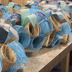 blue and gold burlocked bows are on a table in front of other burlocks