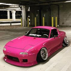 a pink sports car parked in a parking garage