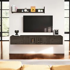 an entertainment center with a flat screen tv mounted on it's wall, in a living room