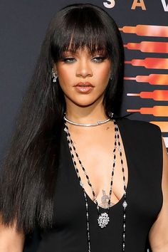 a woman with long black hair wearing a necklace and choker on her neck is posing for the camera