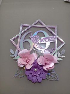 a close up of a metal sign with flowers on the front and back of it